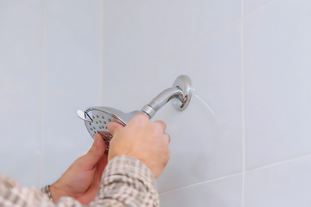 man removing a shower head